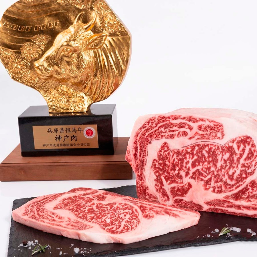 Emblema dorado de la Asociación de Carne de Kobe junto a un ribeye Kobe A5 marmoleado